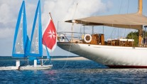 Tiziana at anchor and sailing dinghies